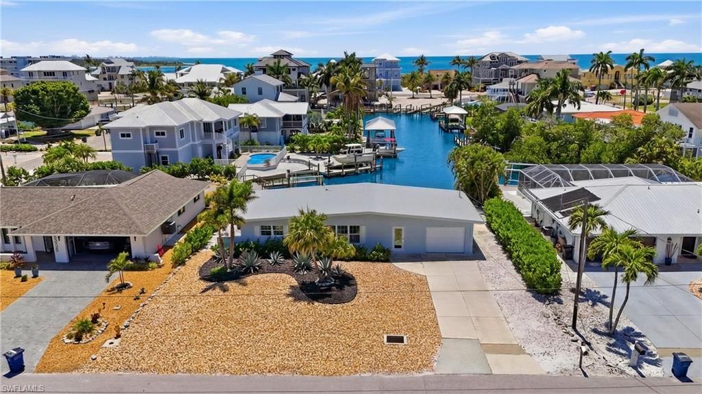 8336 Lagoon Road Fort Myers Beach, FL 33931 - Photo 39 of 50 This property features a single-story residence with a garage and a well-maintained front yard with desert landscaping and tropical plants - Virtually Edited Image