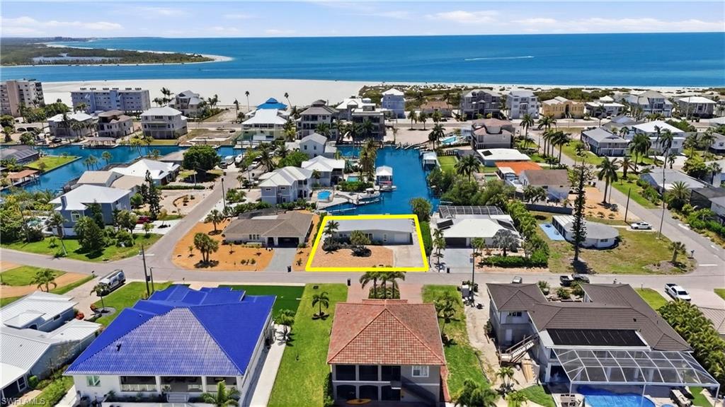 8336 Lagoon Road Fort Myers Beach, FL 33931 - Photo 40 of 50 Aerial view of the property, showcasing its location near canals and a large body of water, with a beach visible in the distance - Virtually Edited Image