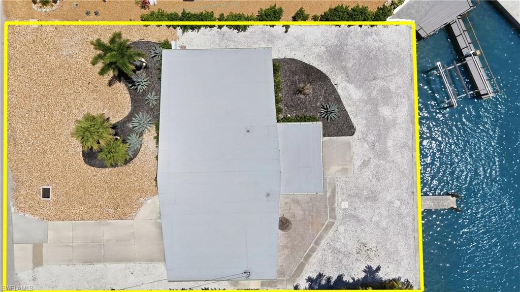 8336 Lagoon Road Fort Myers Beach, FL 33931 - Photo 43 of 50 Aerial view showcasing the property's waterfront location, private dock, and landscaped yard with decorative gravel and plantings - Virtually Edited Image