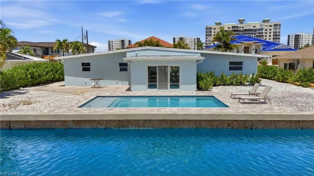 8336 Lagoon Road Fort Myers Beach, FL 33931 - Photo 47 of 50 The property features room for a private swimming pool with a paved surround, lush perimeter landscaping, and a blue exterior - Virtually Edited Image