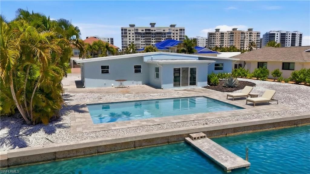 8336 Lagoon Road Fort Myers Beach, FL 33931 - Photo 48 of 50 Exterior view of the property featuring room for a private swimming pool, a concrete patio area, and direct access to a body of water via a small dock - Virtually Edited Image