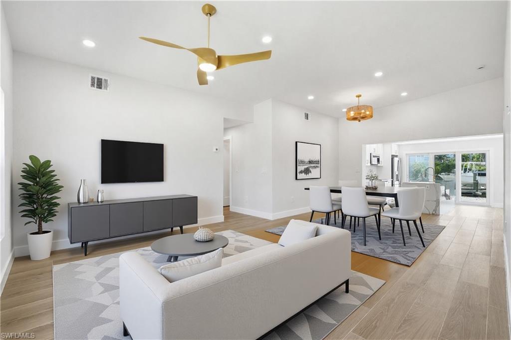 8336 Lagoon Road Fort Myers Beach, FL 33931 - Photo 5 of 50 Bright and open living area featuring light-colored flooring, recessed lighting, and a vaulted ceiling with a modern ceiling fan - Virtually Edited Image