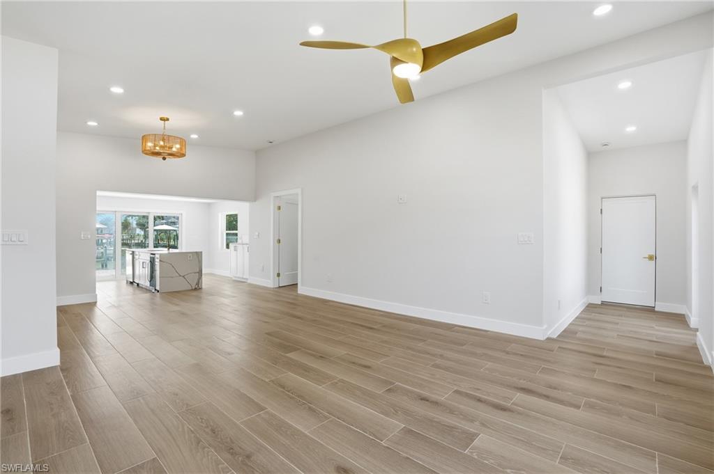 8336 Lagoon Road Fort Myers Beach, FL 33931 - Photo 6 of 50 Spacious living area featuring light wood-look flooring, recessed lighting, and a modern ceiling fan - Virtually Edited Image