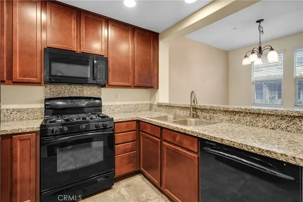 a kitchen with granite countertop stainless steel appliances a stove sink and microwave