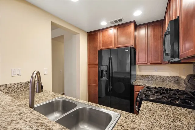 a kitchen with stainless steel appliances granite countertop a refrigerator and a sink