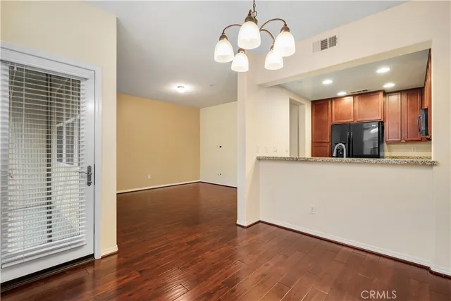 a view of a room with wooden floor and chandelier
