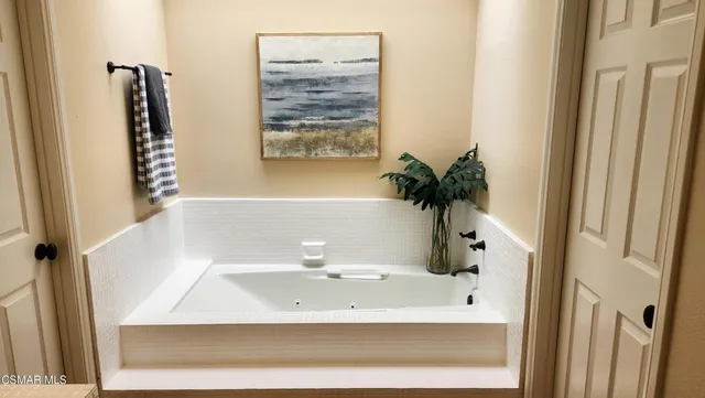a white bath tub sitting in a bathroom next to a window