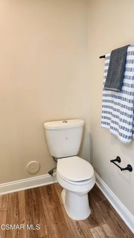 a white toilet sitting next to a white wall