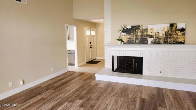 a view of a livingroom with wooden floor and a fireplace