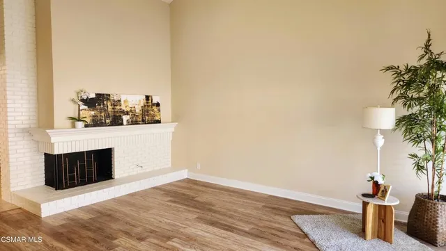 a view of a room with wooden floor and potted plants