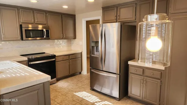 a kitchen with stainless steel appliances a refrigerator stove and microwave