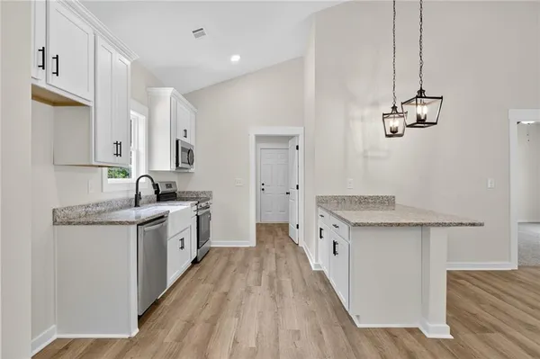 a kitchen with granite countertop a sink stove and cabinets