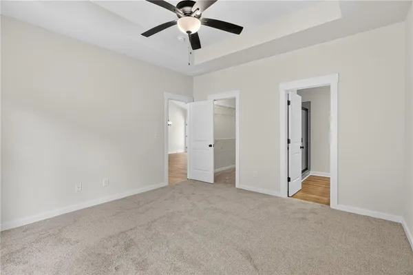 an empty room with closet and a chandelier fan