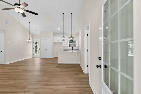 a view of a kitchen with wooden floor and a ceiling fan