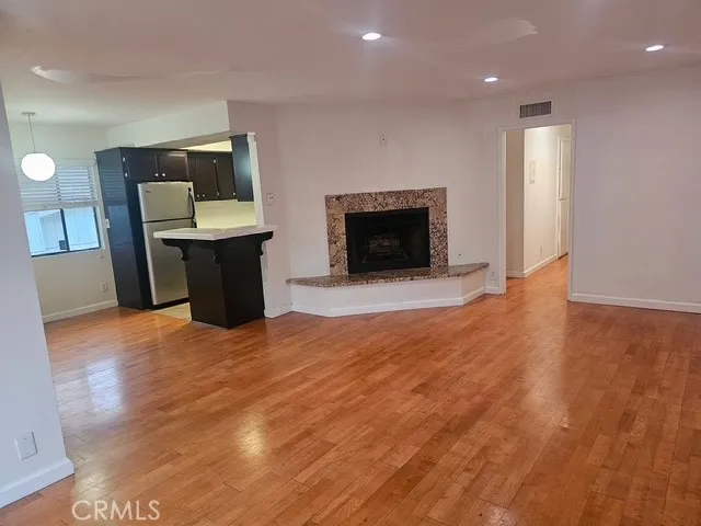an empty room with wooden floor and fireplace
