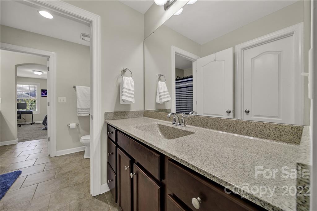 1557 Hazel Street Tega Cay, SC 29708 - Photo 30 of 47 a bathroom with a granite countertop sink and a mirror