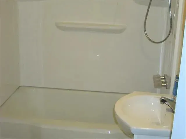 a bathroom with a white bath tub and a shower