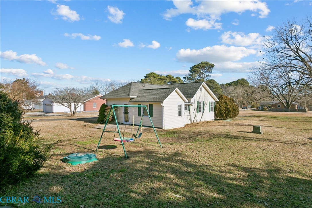 2290 Hayes Road Hayes, VA 23072 - Photo 30 of 32 Rear view of property with a playground, a yard, and a shingled roof