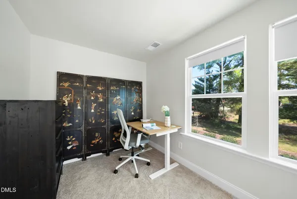 a bed sitting in a spacious bedroom next to a window