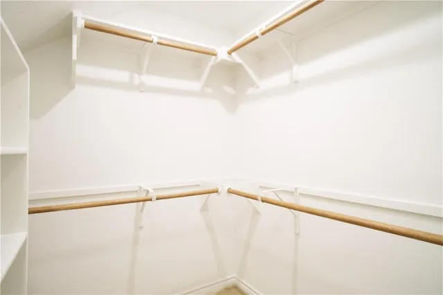 a view of walk in closet with empty racks