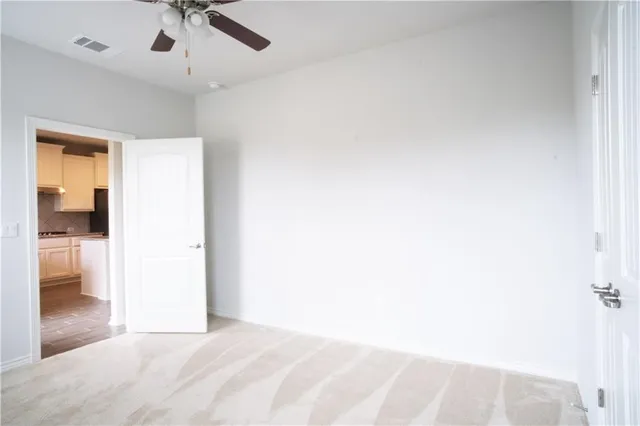 an empty room with a window and ceiling fan