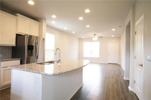 a kitchen with kitchen island a sink appliances and cabinets