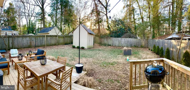 a view of a backyard with table and chairs potted plants and wooden fence
