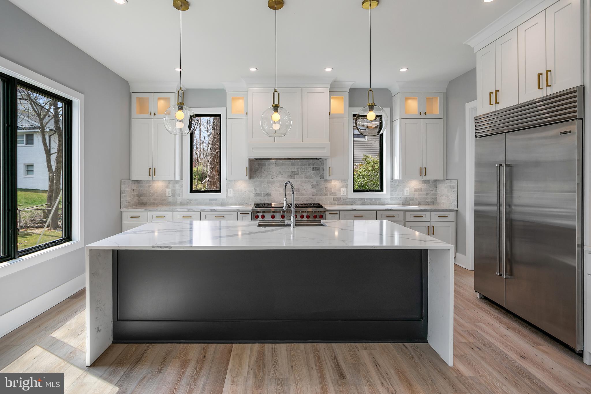 7019 Statendam Court McLean, VA 22101 - Photo 7 of 52 a kitchen with stainless steel appliances granite countertop a sink a refrigerator and a wooden floor