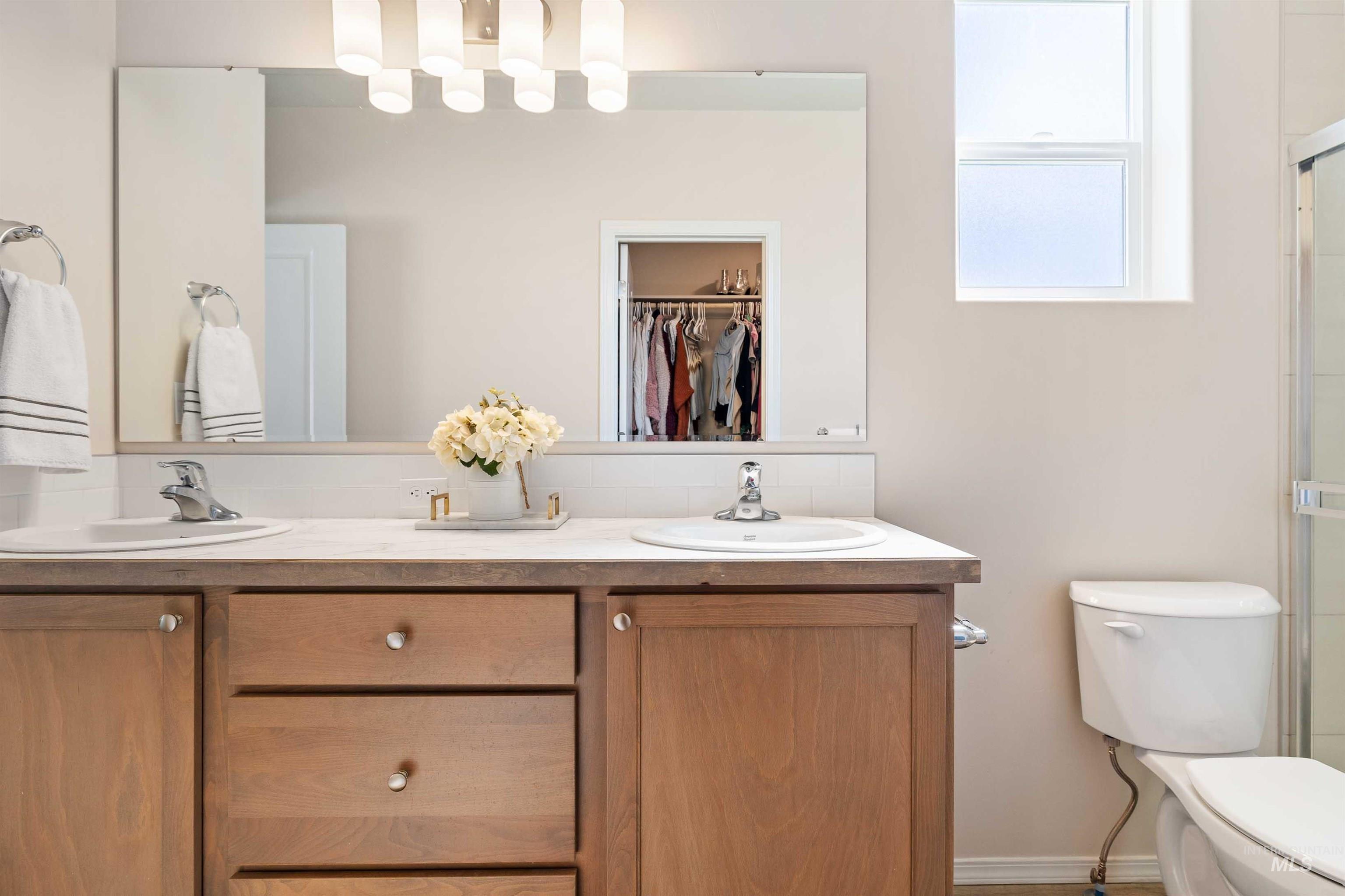 1603 Kenyon Mdw Street Twin Falls, ID 83301 - Photo 13 of 34 Bathroom with double vanity, a walk in closet, and a shower with door