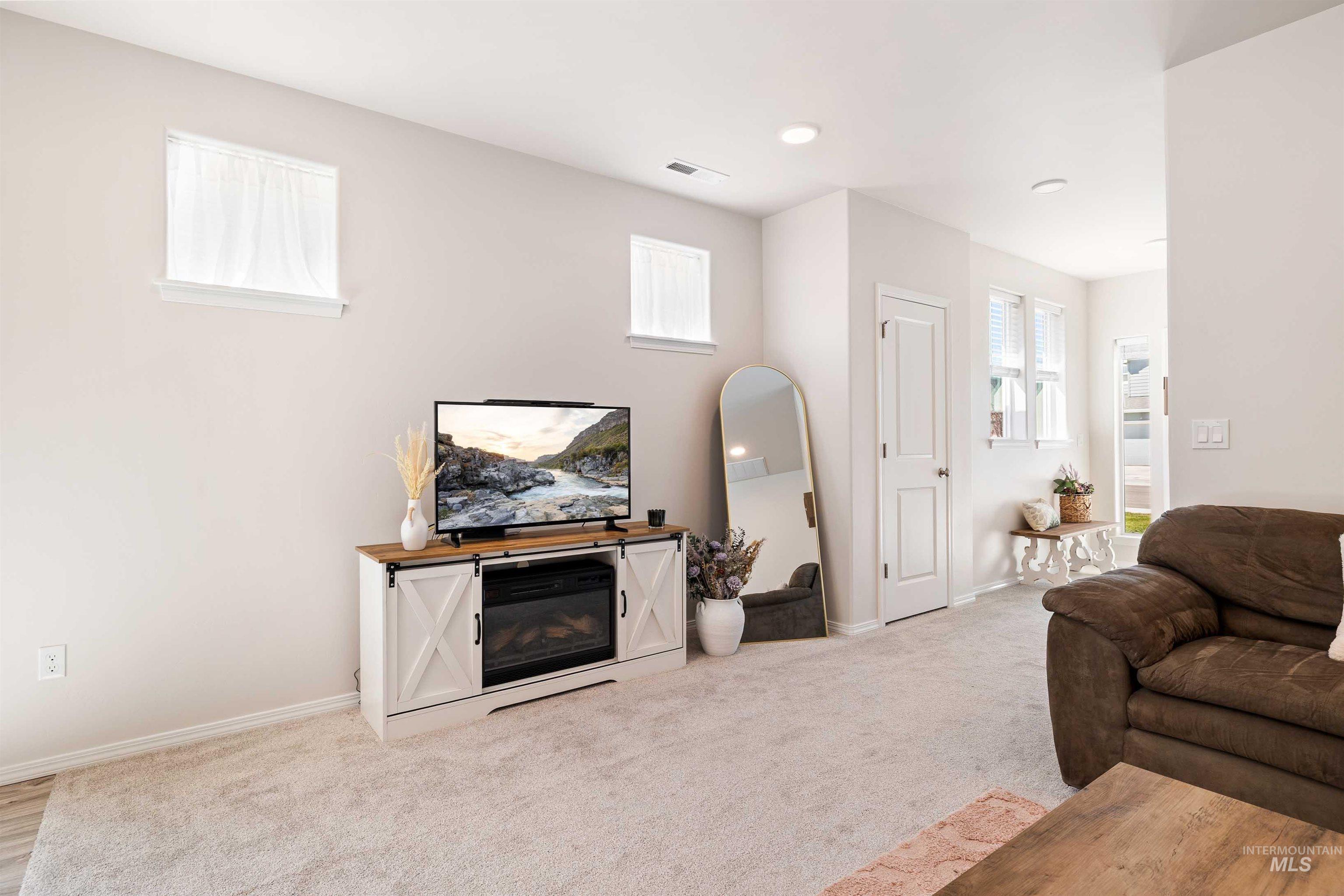 1603 Kenyon Mdw Street Twin Falls, ID 83301 - Photo 7 of 34 Living room featuring light colored carpet and a glass covered fireplace