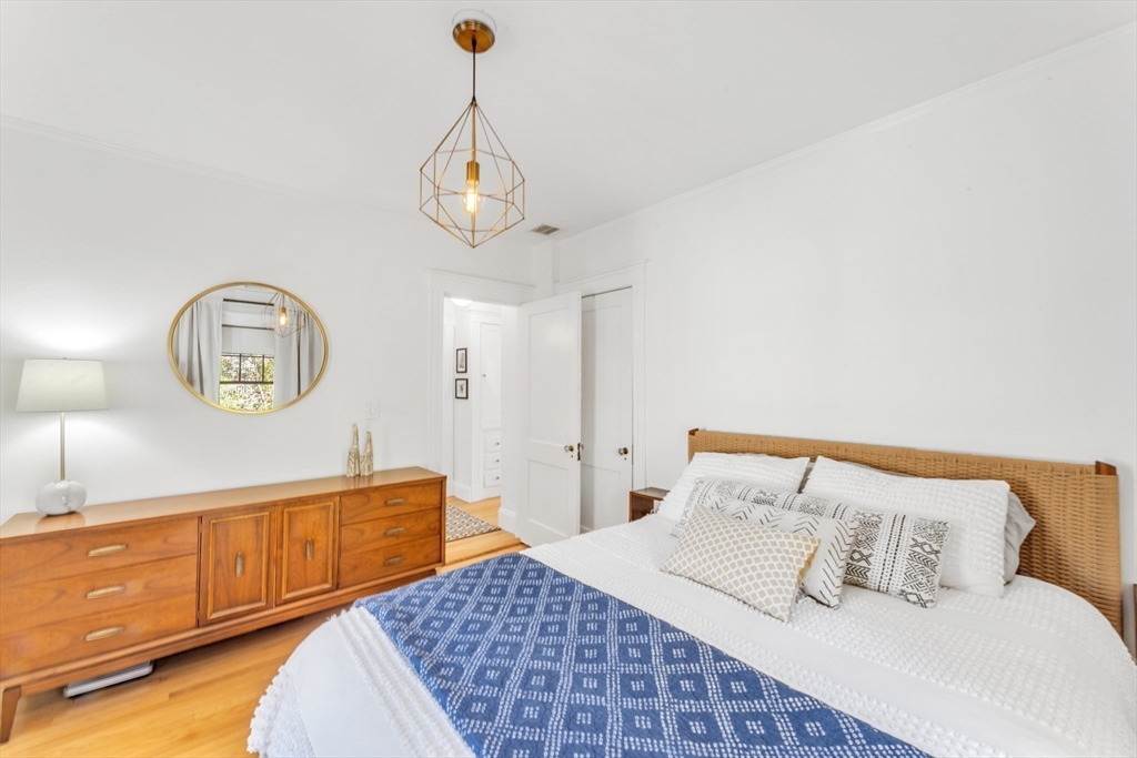 6 Arborough Road, Unit 2 Boston, MA 02131 - Photo 27 of 40 a bedroom with a bed a dresser and potted plants on the dresser