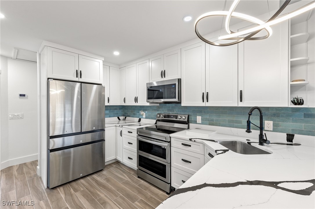838-840 Rabbit Road Sanibel, FL 33957 - Photo 21 of 38 a kitchen with a refrigerator sink and cabinets