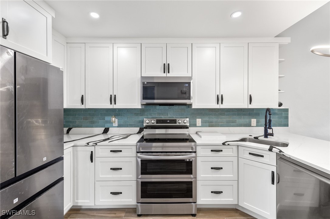 838-840 Rabbit Road Sanibel, FL 33957 - Photo 23 of 38 a kitchen with white cabinets and appliances
