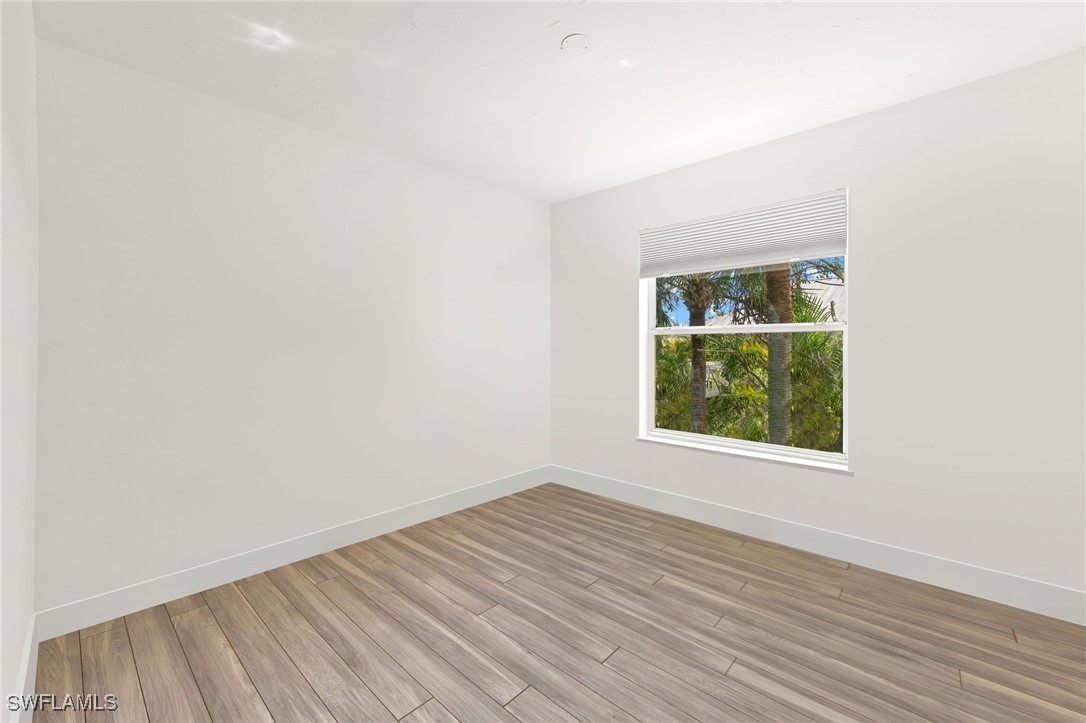 838-840 Rabbit Road Sanibel, FL 33957 - Photo 25 of 38 an empty room with wooden floor and windows