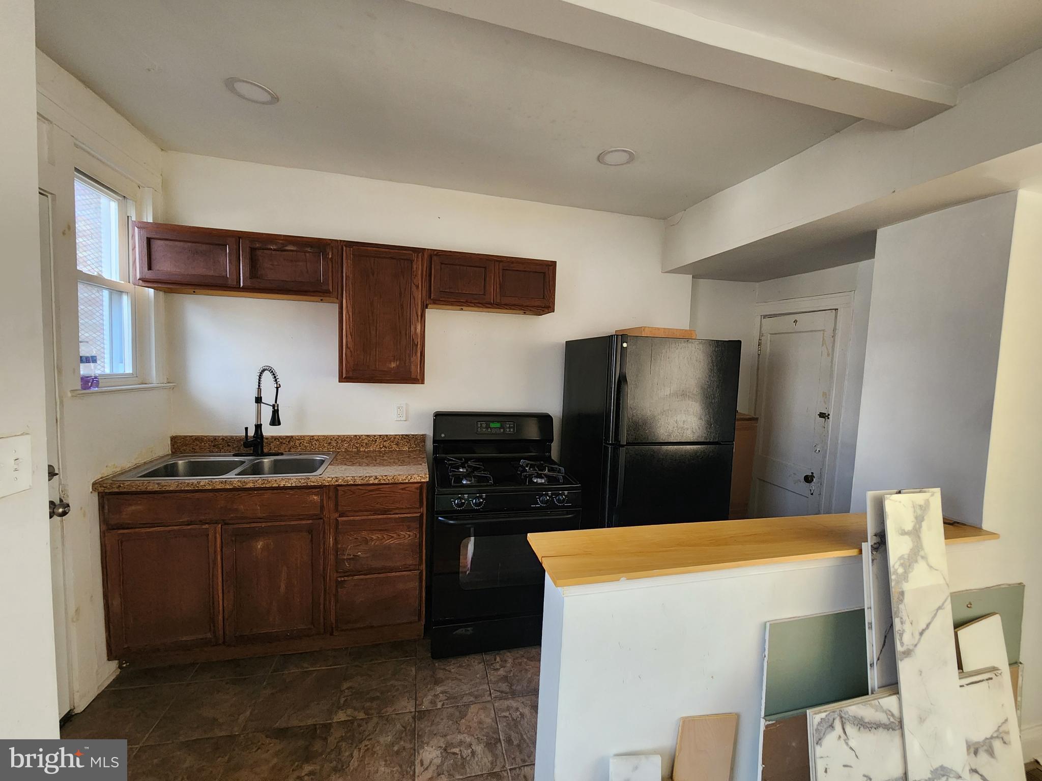 3208 Elmley Avenue Baltimore, MD 21213 - Photo 11 of 30 a kitchen with stainless steel appliances a sink a stove a refrigerator a counter top space and cabinets