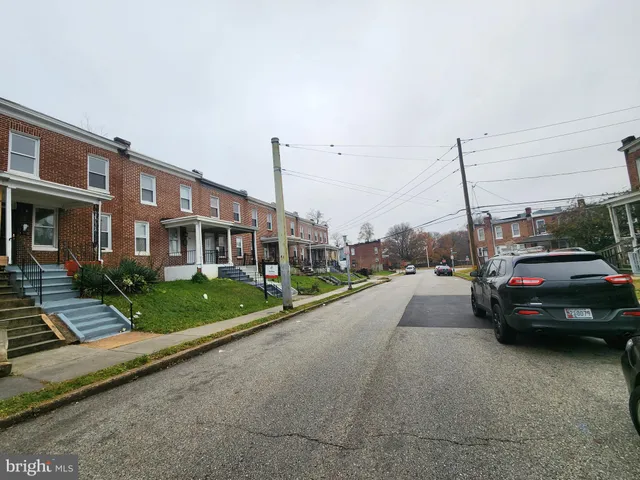 a view of a city street with a car parked on the road