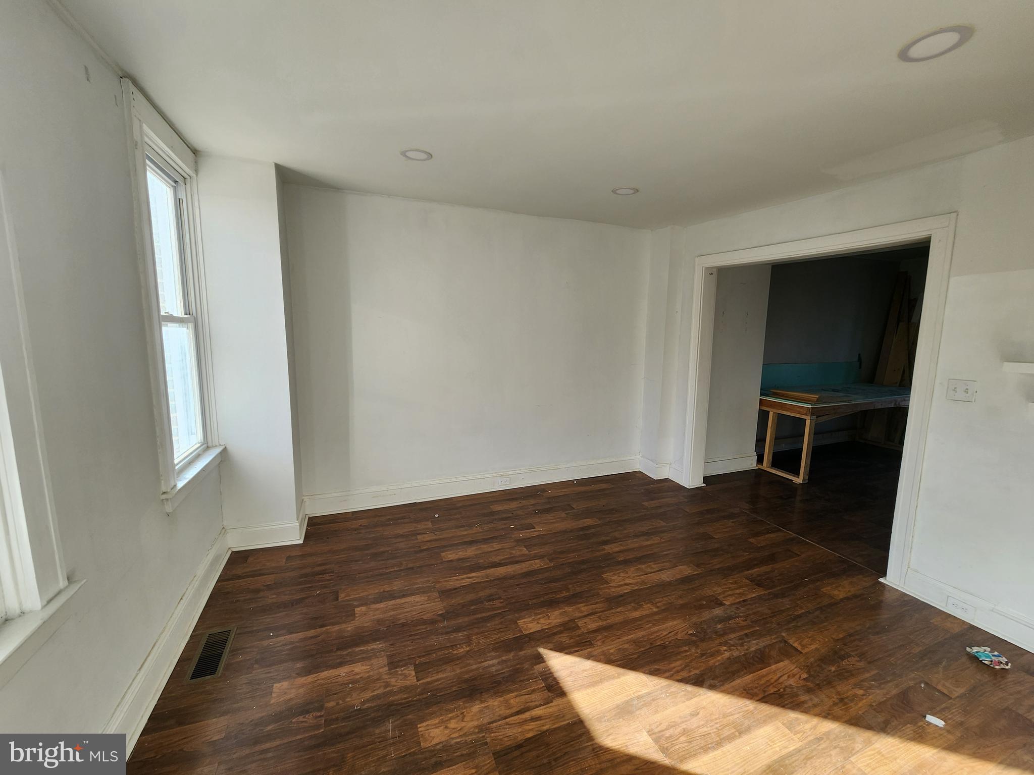 3208 Elmley Avenue Baltimore, MD 21213 - Photo 6 of 30 a view of an empty room with wooden floor and a window