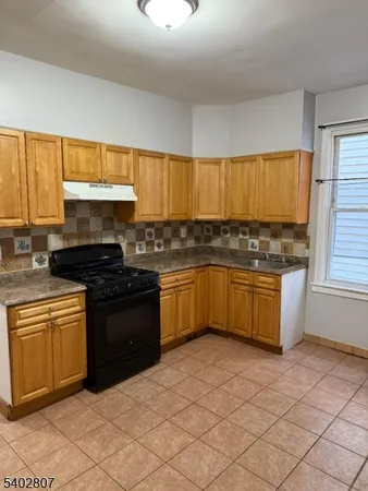 a kitchen with granite countertop a stove a sink dishwasher and a refrigerator
