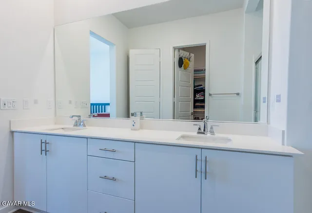a bathroom with a double vanity sink and mirror