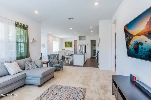 a living room with furniture kitchen view and a window