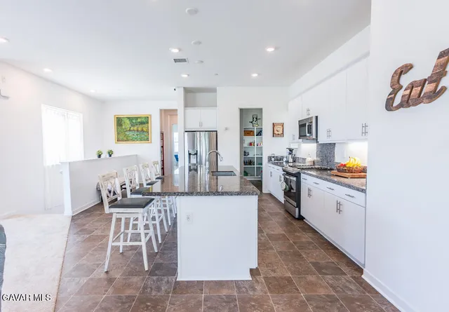 a kitchen with stainless steel appliances kitchen island granite countertop a sink and cabinets