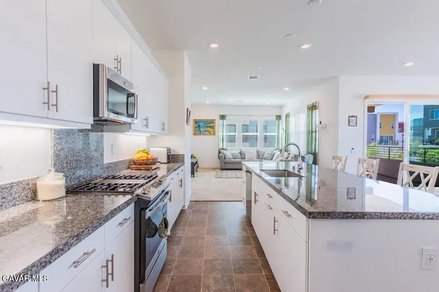 a kitchen with stainless steel appliances granite countertop a sink and stove