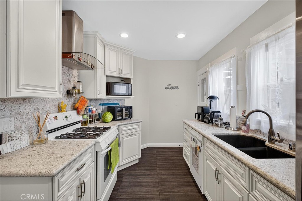 1524 East Hellman Street Long Beach, CA 90813 - Photo 18 of 33 a kitchen with stainless steel appliances granite countertop a sink stove and cabinets