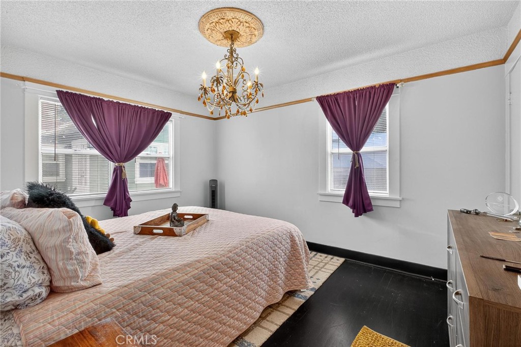 1524 East Hellman Street Long Beach, CA 90813 - Photo 21 of 33 a bedroom with a bed and a chandelier