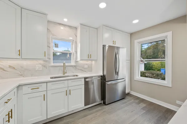 a kitchen with a refrigerator sink and cabinets
