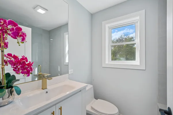 a bathroom with a sink vanity mirror and toilet