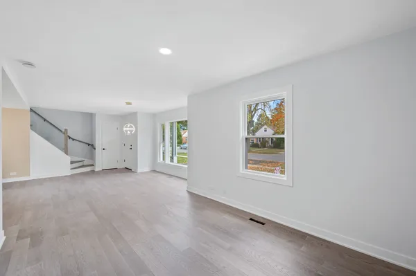 an empty room with windows and wooden floor