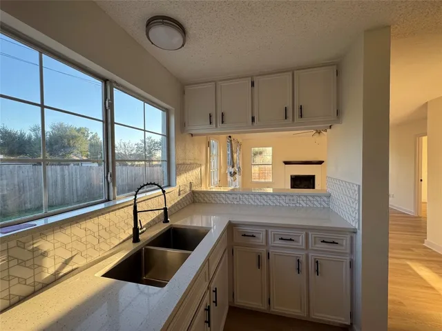 a kitchen with granite countertop a sink and a refrigerator