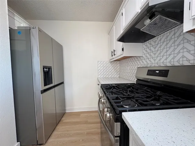 a kitchen with stainless steel appliances granite countertop a stove and a refrigerator