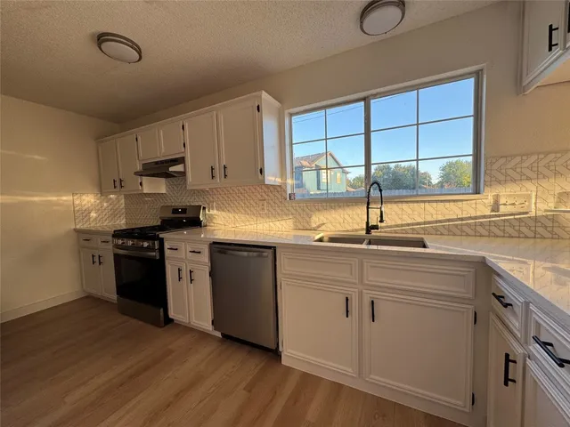 a kitchen with a sink cabinets and window